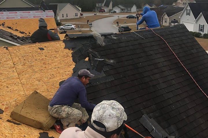 Melvin's Roofing crew tearing off old shingles on a re-roof