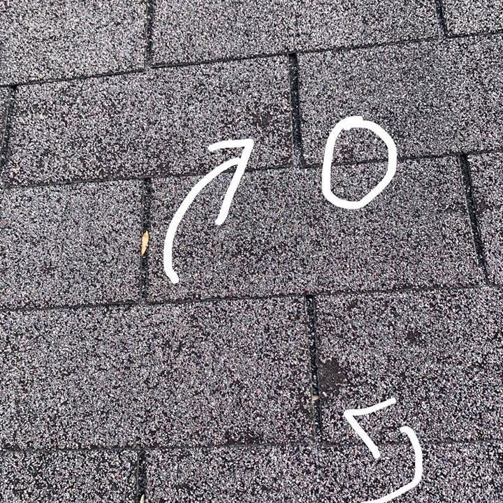 Damaged shingles marked during a roof inspection